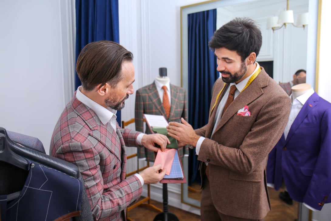 Tailor with Client Choosing Fabric for Bespoke Suit  in Atelier